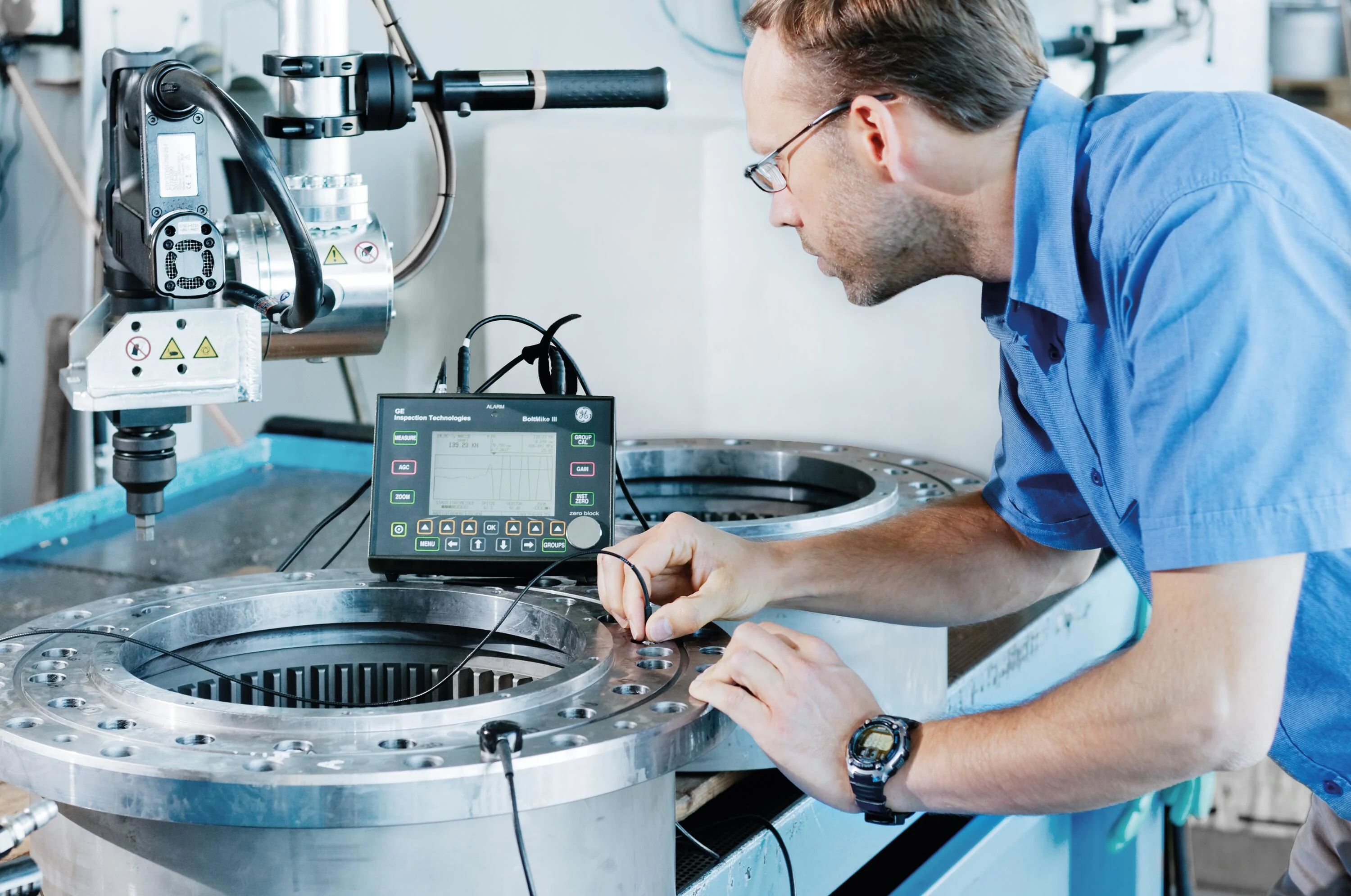 一位男性工程师在工业应用中使用探头进行超声预载测量。
