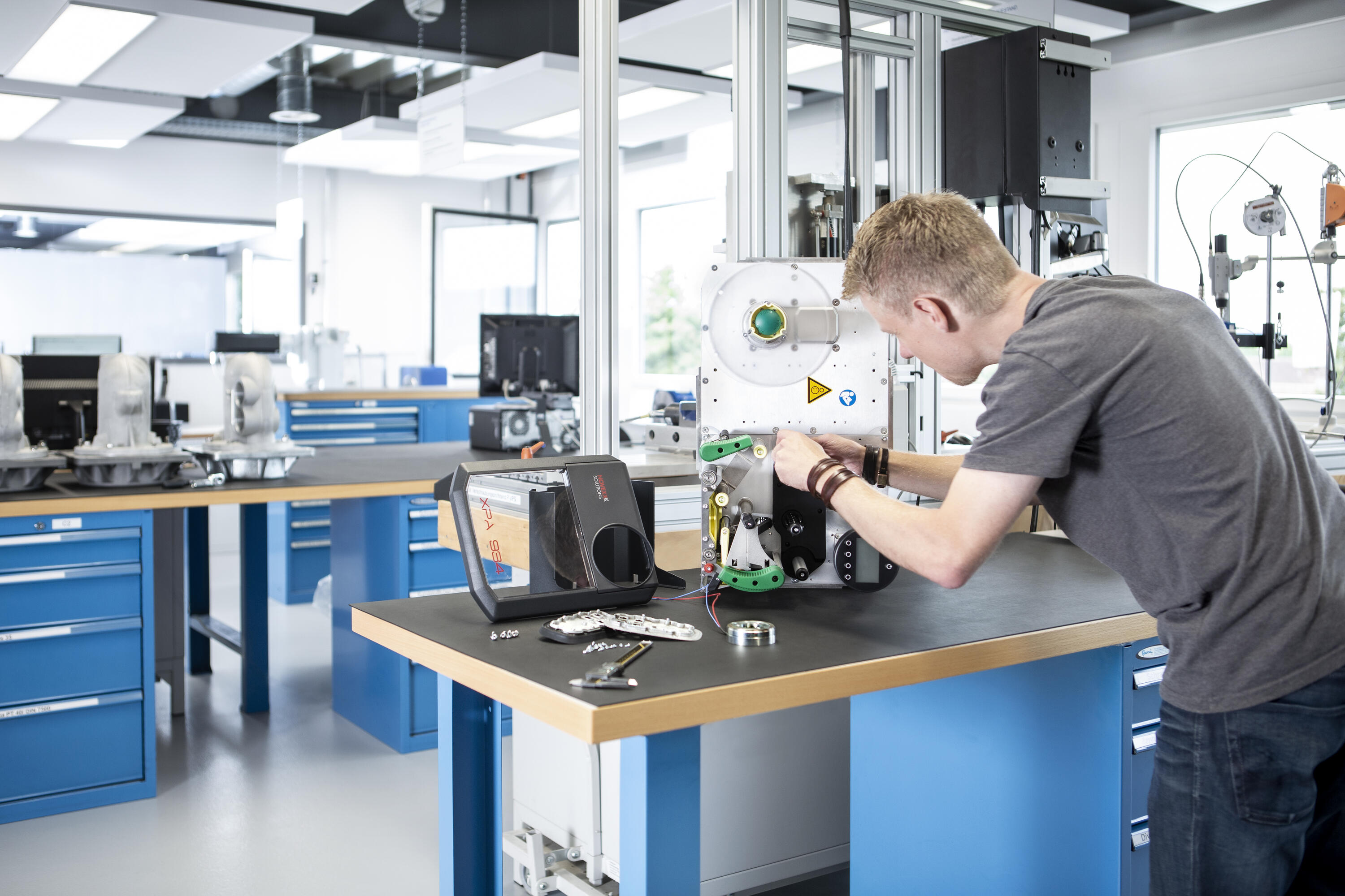 Engineer disassembling an application in a technical lab to analyze fasteners and joints. Key visual for Expert Teardown only.