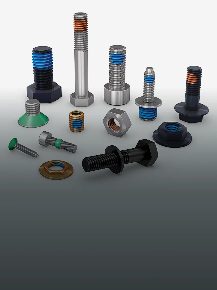 Different screws, nuts, and threaded inserts with different types of coating solutions, such as functional coating patches, on a grey background
