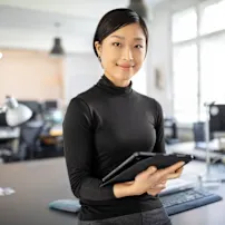 Female designer in her office, holding a tablet in her hands
