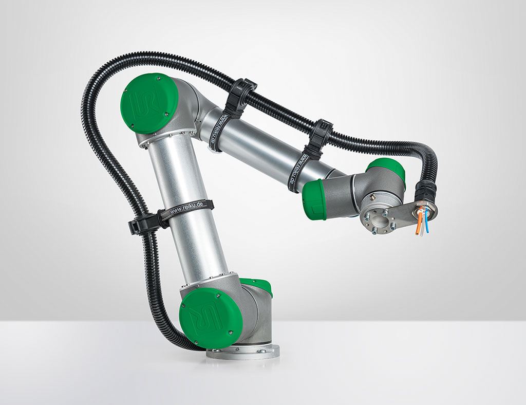Silver and green collaborative robotic arm with black cable conduit and orange-blue wires at end effector on white surface.