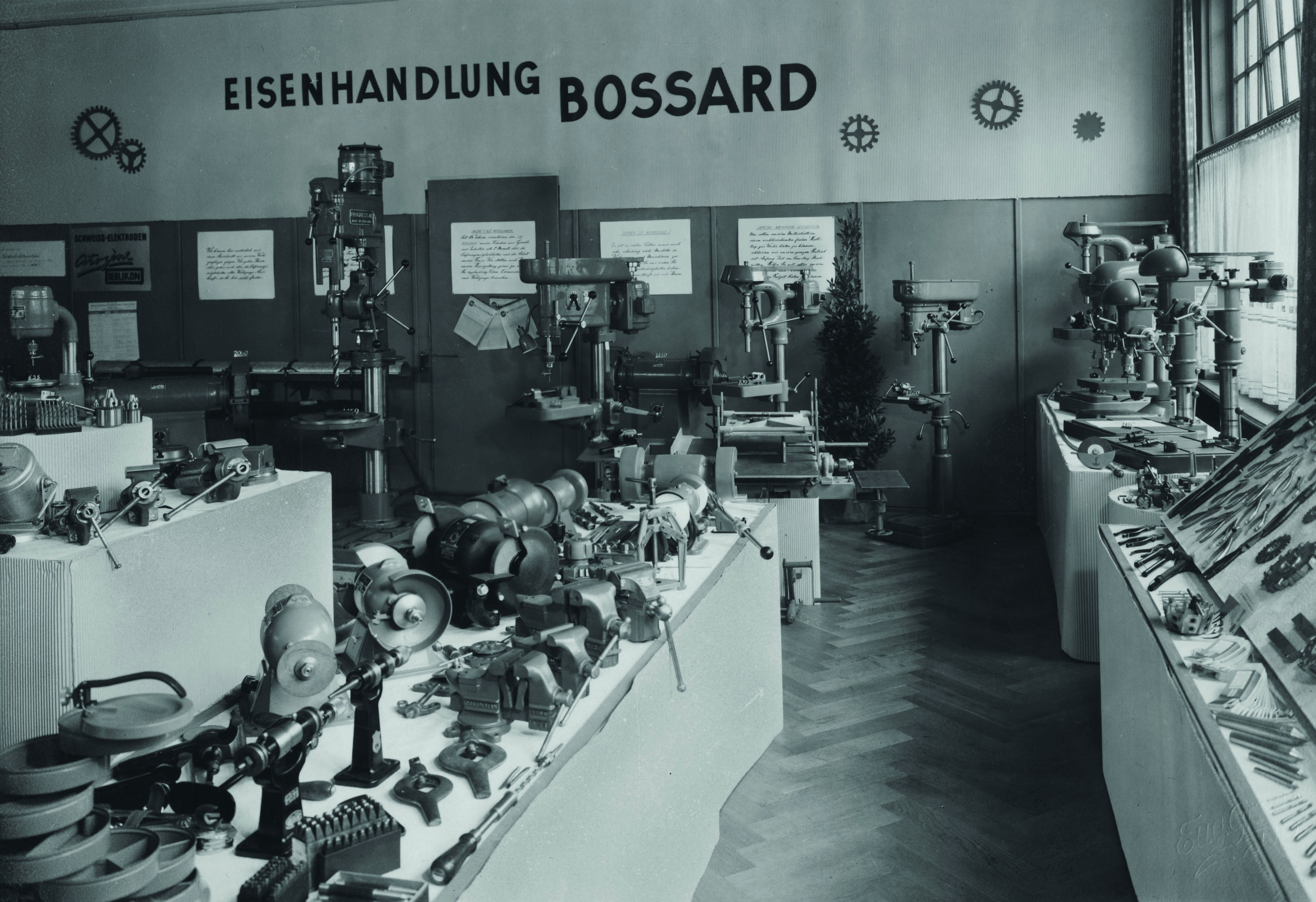 一张1930年代Bossard五金店的黑白老照片，店内摆满了各种工具和设备。