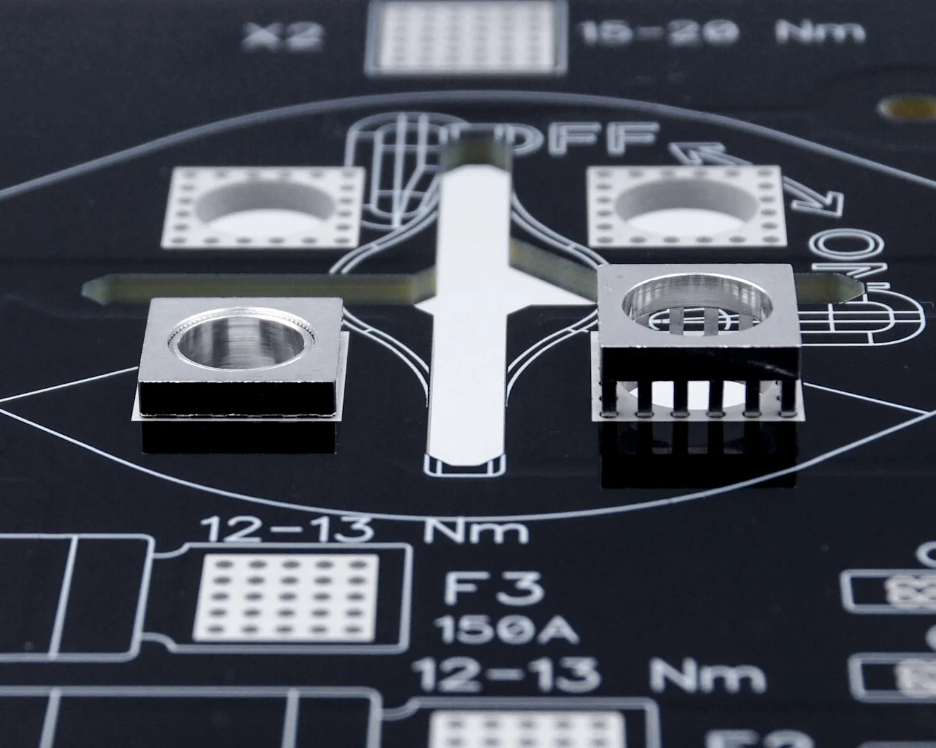 Close-up of a black PCB with MTCON power elements, three already pressed in, one still to be assembled
