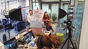A group of individuals collaborating on laptops in a video recording studio at Bossard during an active recording session.