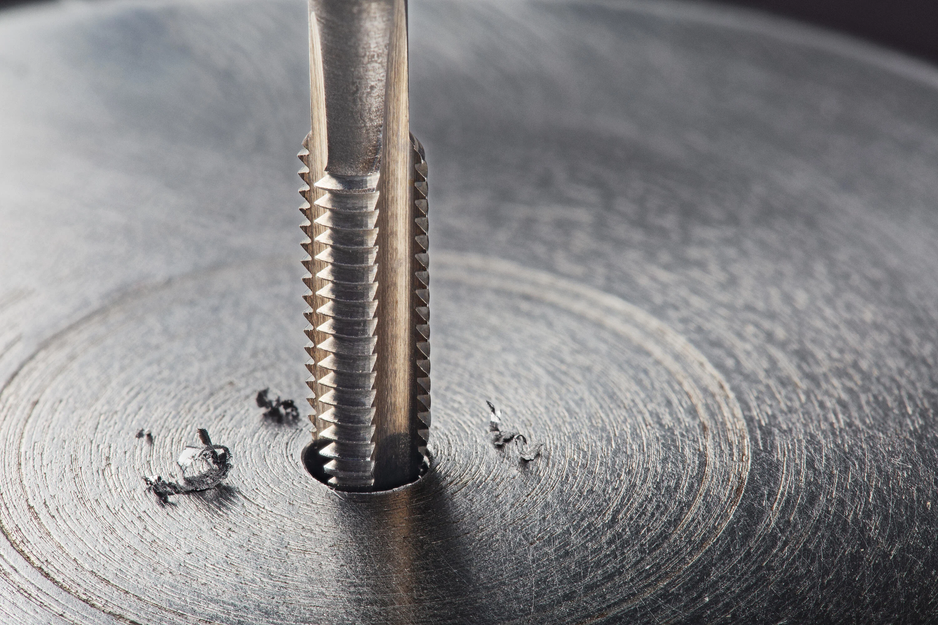 Thread tap that drills into a metal surface