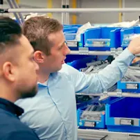 Two men at a screen point to the elam solutions shown