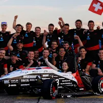 The AMZ team stands with their car for a group photo, full of energy and enthusiasm.