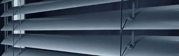 窗户的特写，白色百叶窗部分拉开，柔和的光线透过。