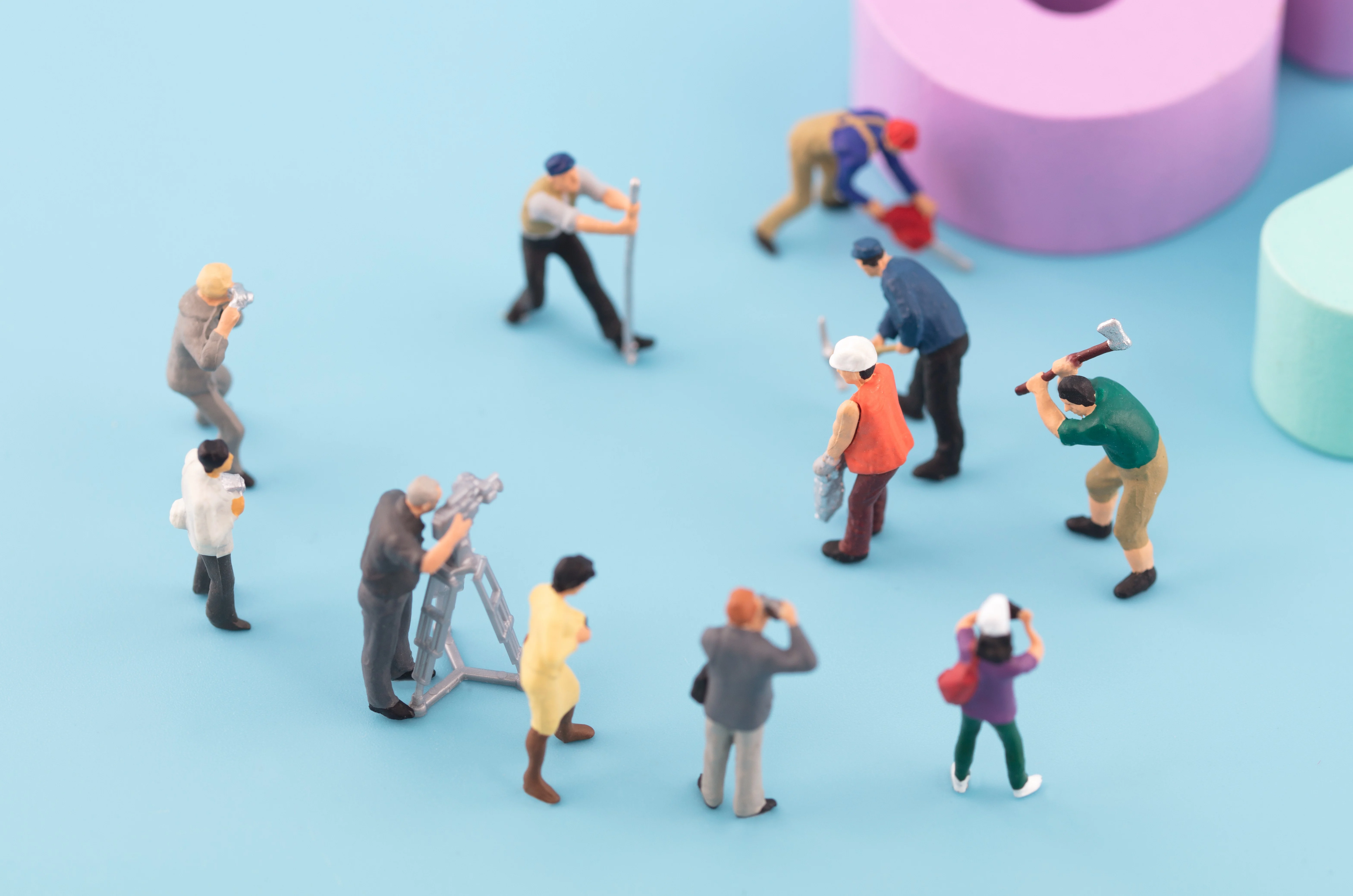 蓝色表面上带有工具和梯子的微型工人模型,配有大型淡紫色和薄荷绿色物体。