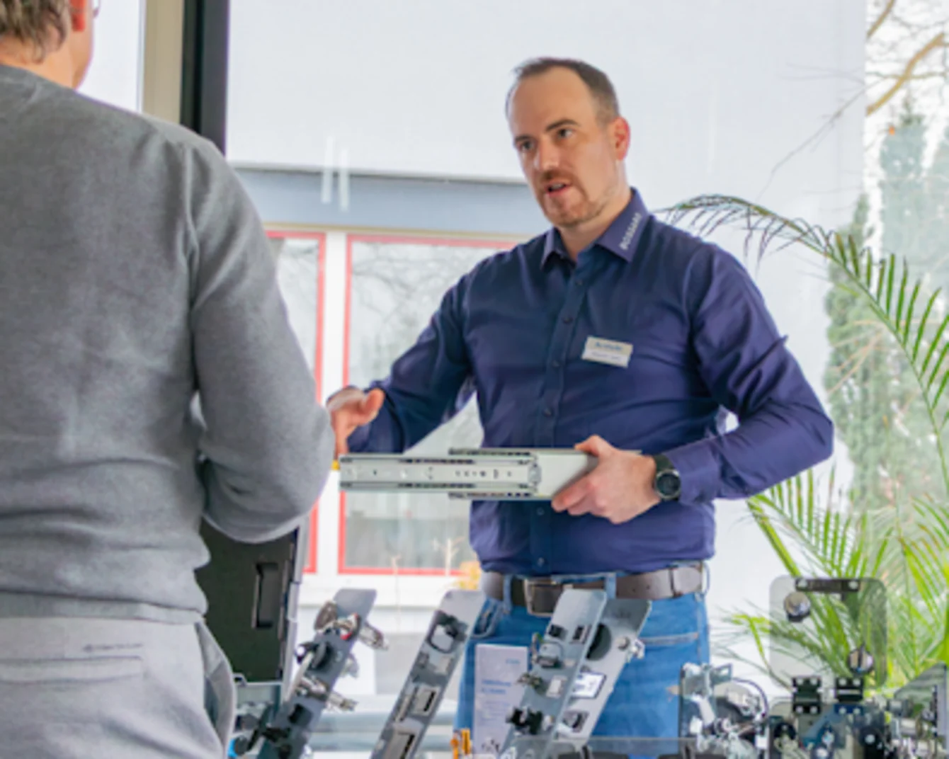 Bossard employee presenting technical components to a visitor during a personal consultation at a TechDay event.