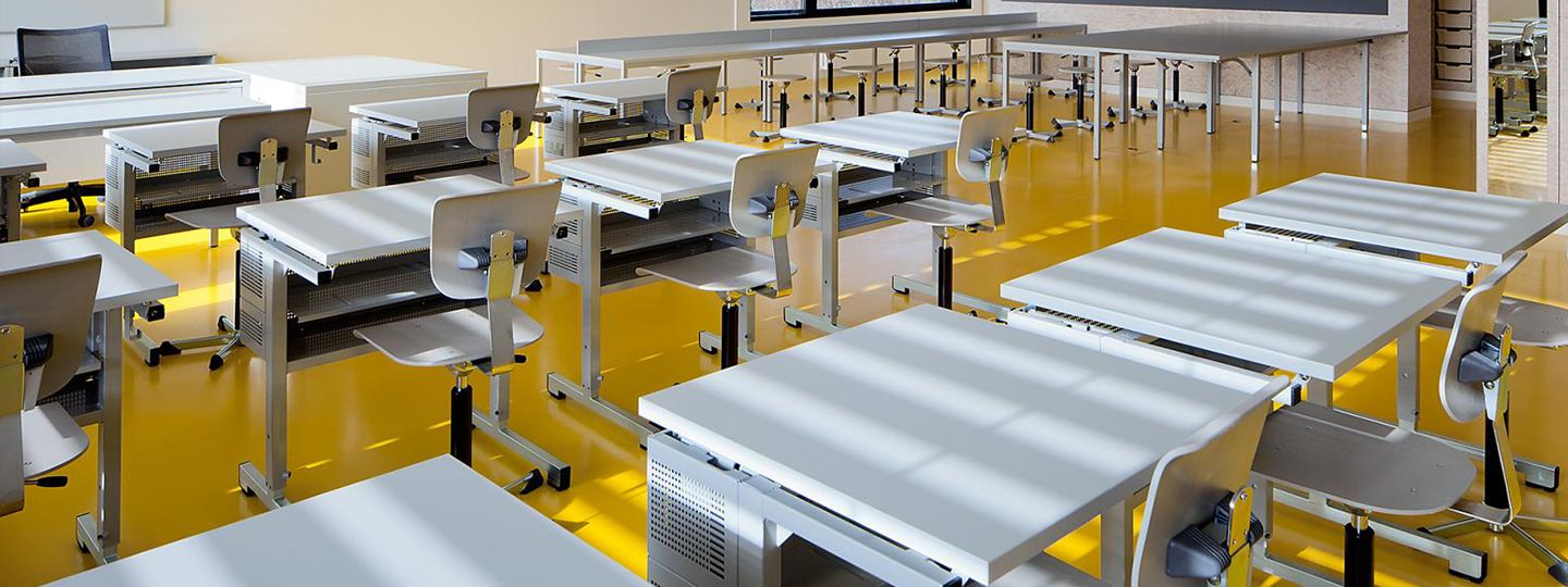 An organized classroom with multiple desks and Embru school chairs