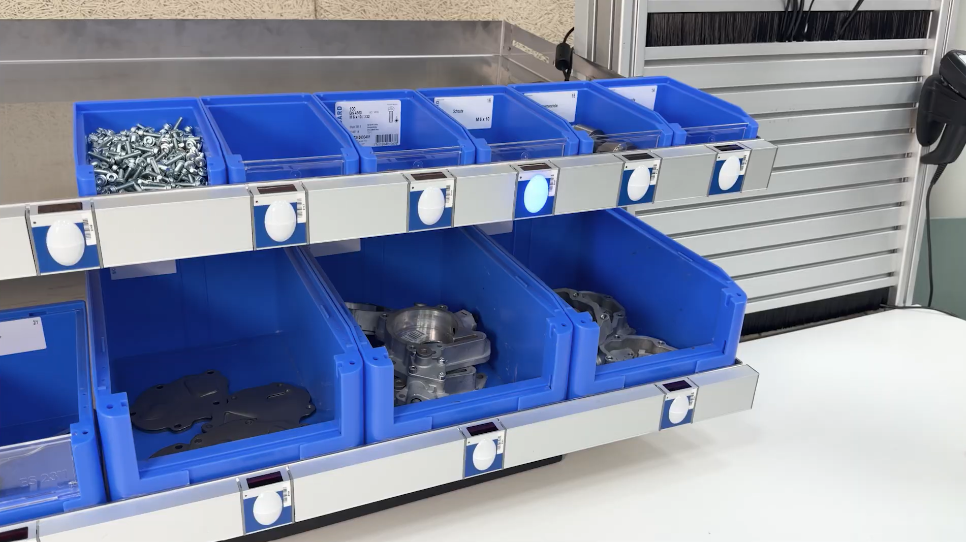 Bossard Pick-to-Light system with blue bins at a workstation in the assembly area