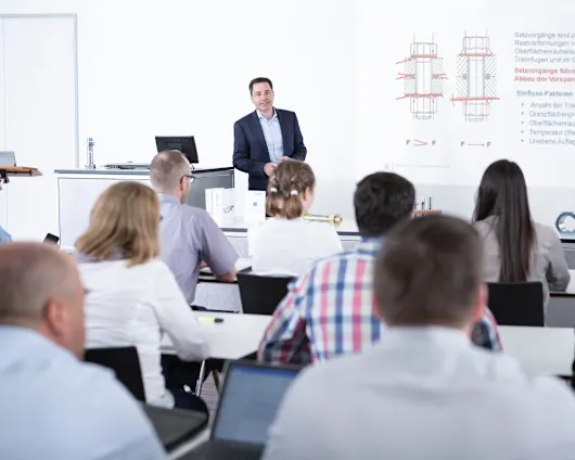 People in a classroom attending a seminar on fastening technology. Key visual for Expert Education only.