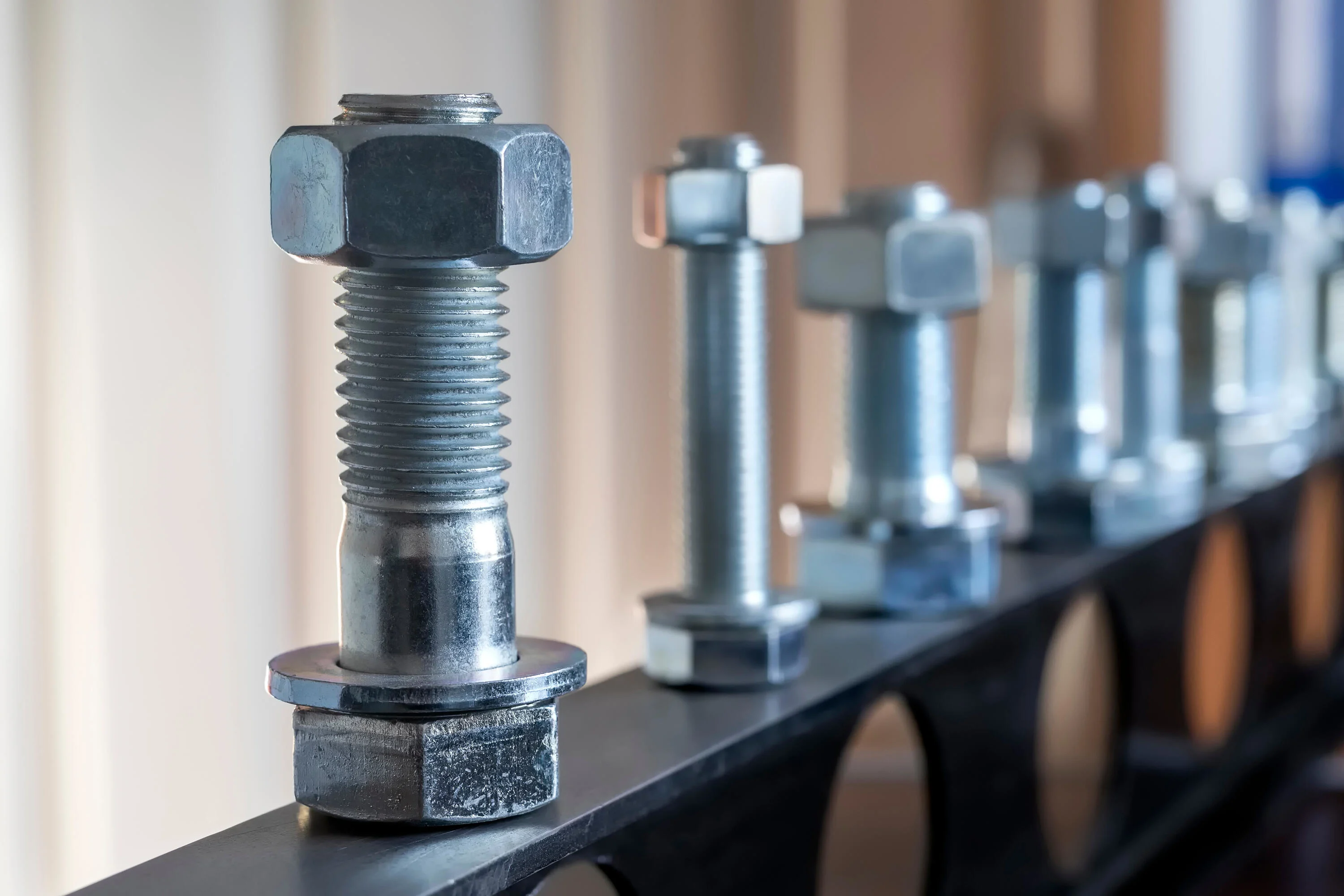 View of fasteners: bolts, nuts, and washers. Bolts assemble two unthreaded components with a nut, while screws are used with threaded components.