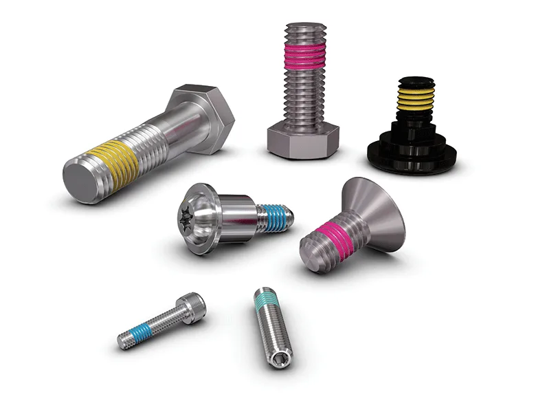 Seven various fasteners with thread covered with Precote coating on a white background.
