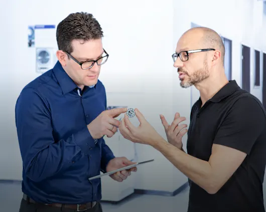 Two people discussing design of a fastener.