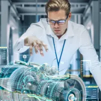 Engineer in a white shirt looking at a 3D graphic model of machine.