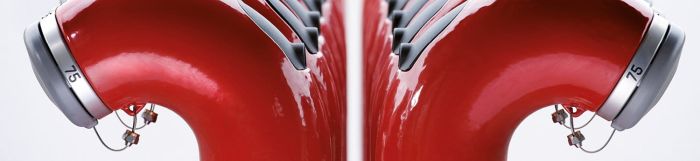 Two rows of red fire hydrants with silver caps and numbers, viewed from the side, creating a symmetrical pattern.