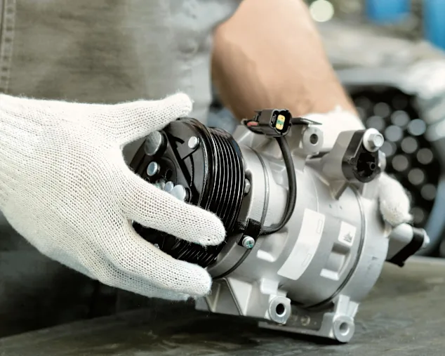 A technician inspects an HVAC compressor.