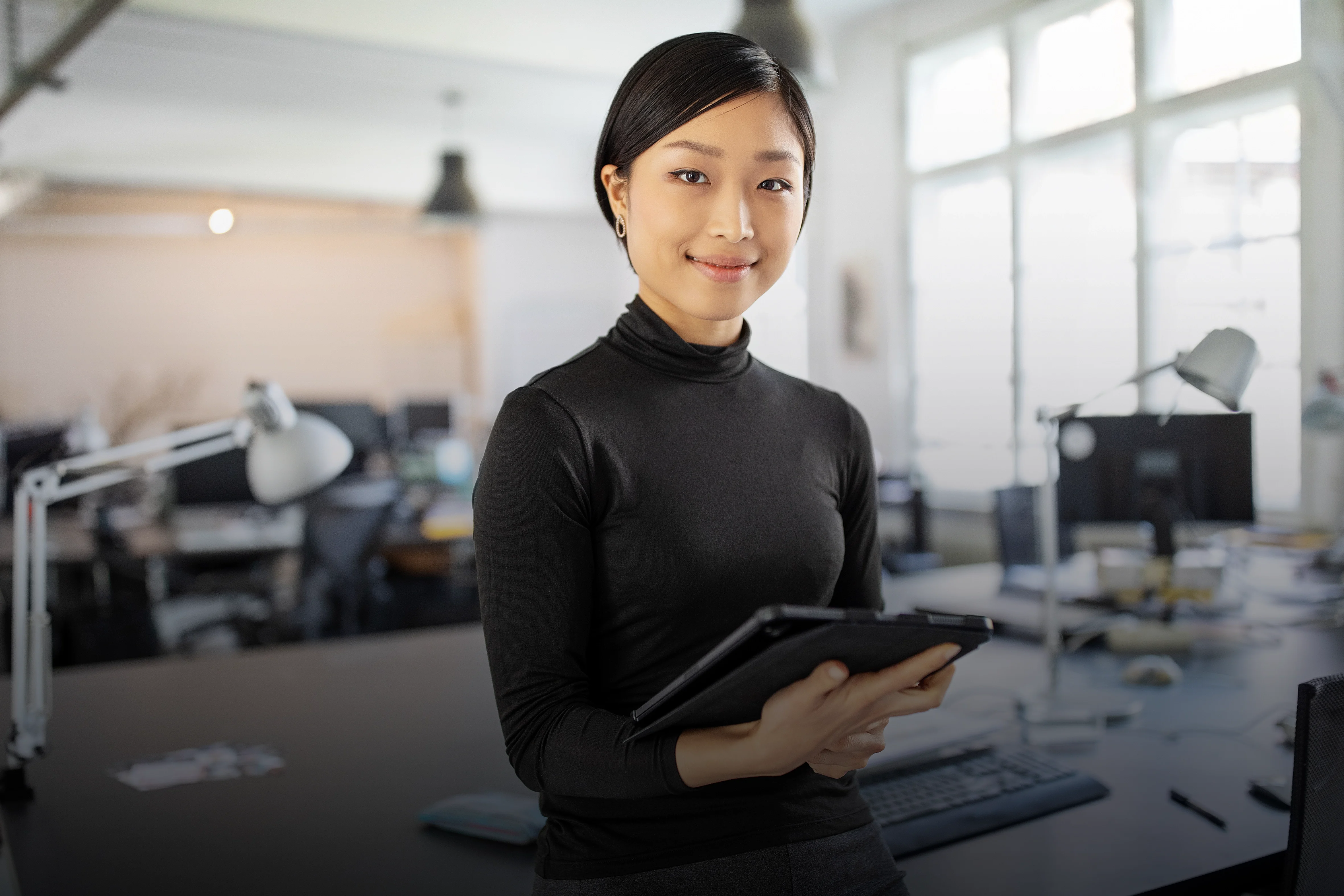 Female designer in her office, holding a tablet in her hands