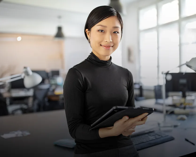 Female designer in her office, holding a tablet in her hands