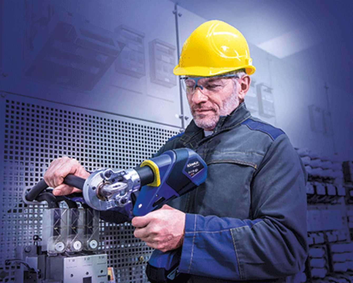A man in a hard hat using a Klauke crimping tool