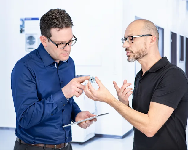 Two people discussing design of a fastener.