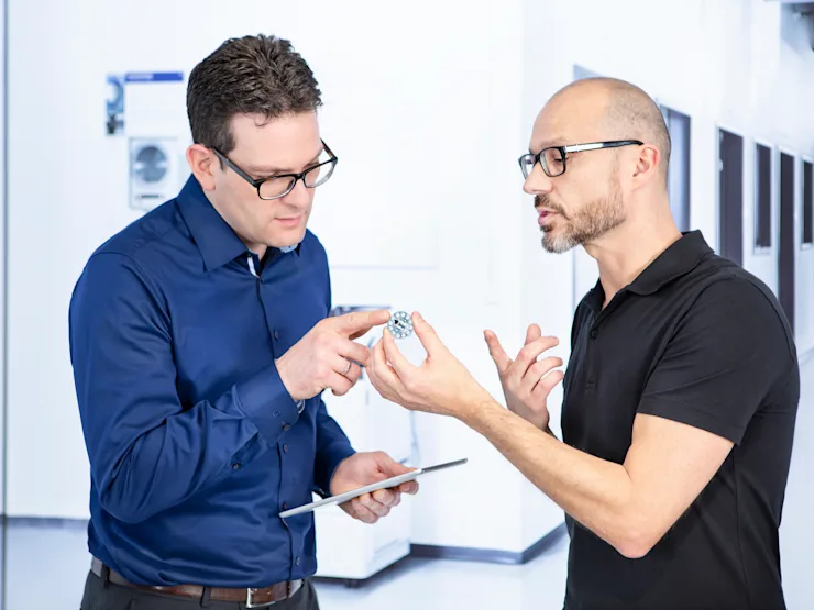 Two people discussing design of a fastener.