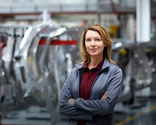 Female assembly manager standing in automotive production facility
