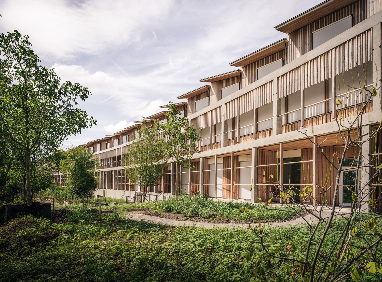 A wooden building with windows, representing the Zurich Children's Hospital, has a modern wooden façade.