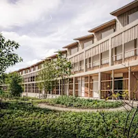 A wooden building with windows, representing the Zurich Children's Hospital, has a modern wooden façade.