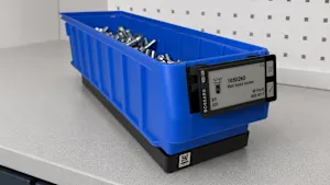 Blue plastic storage bin with label containing hex head screws in workshop setting.