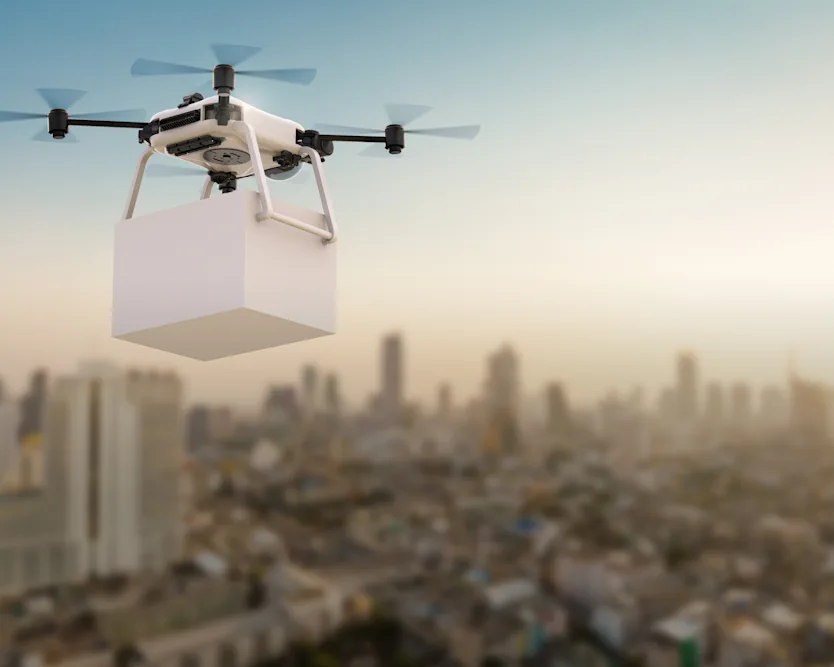 A futuristic drone soaring above a cityscape, symbolizing the advancement of drone delivery technology.