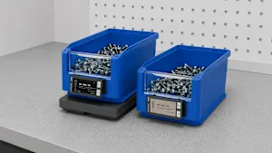Two blue plastic storage bins filled with screws, each with a digital display label showing inventory numbers and quantities.