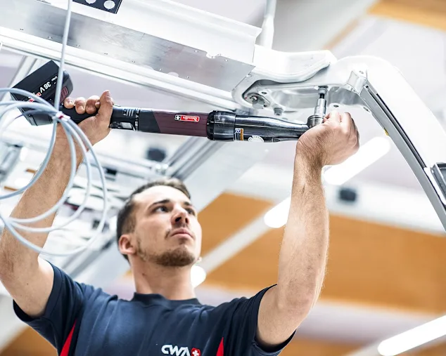 A man using a smart tool to fasten a screw into aluminium.