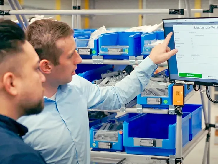 Two men at a screen point to the elam solutions shown