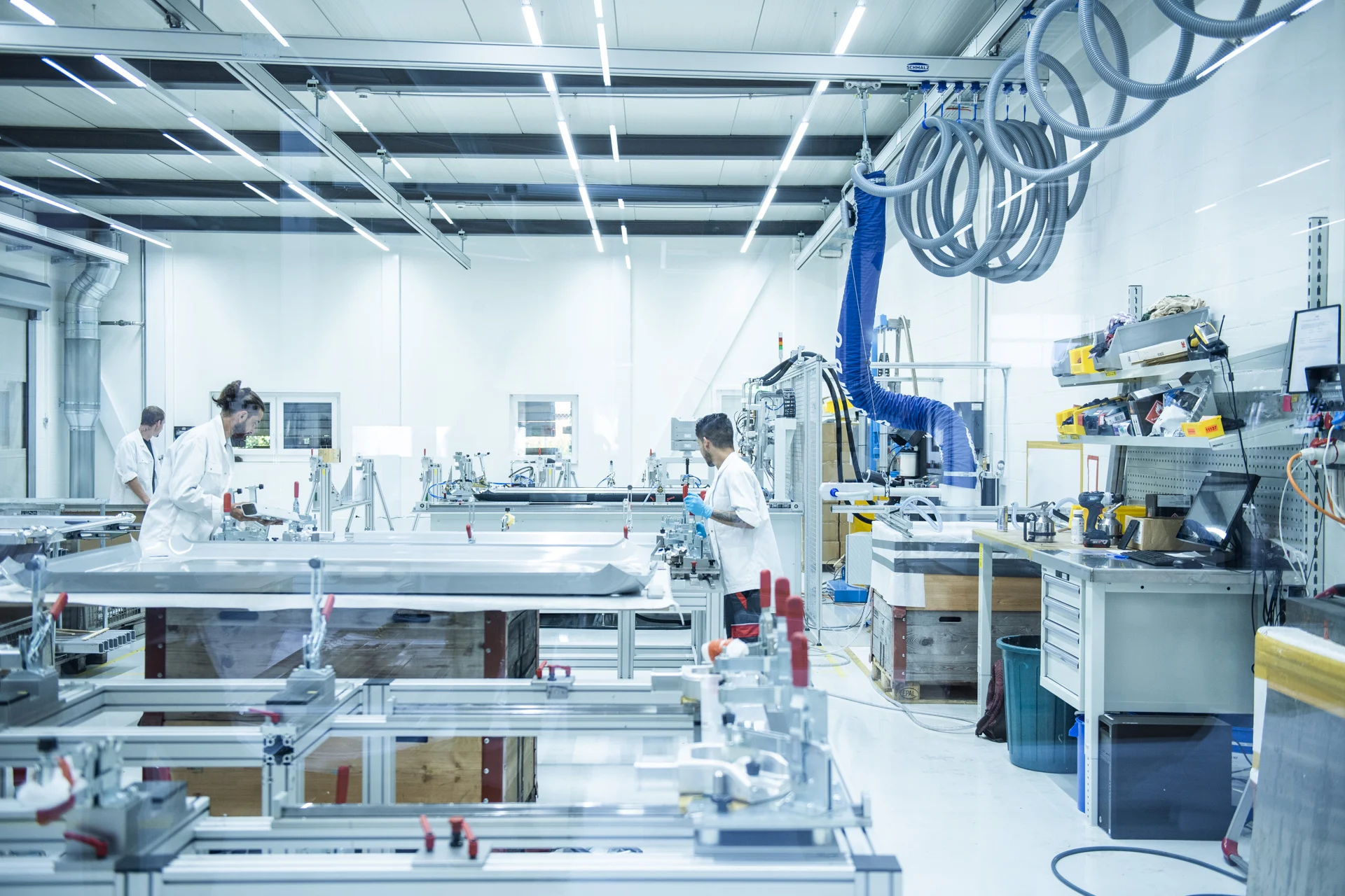 3 workers in an isolated assembly room, with controlled environment.