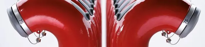 Two rows of red fire hydrants with silver caps and numbers, viewed from the side, creating a symmetrical pattern.