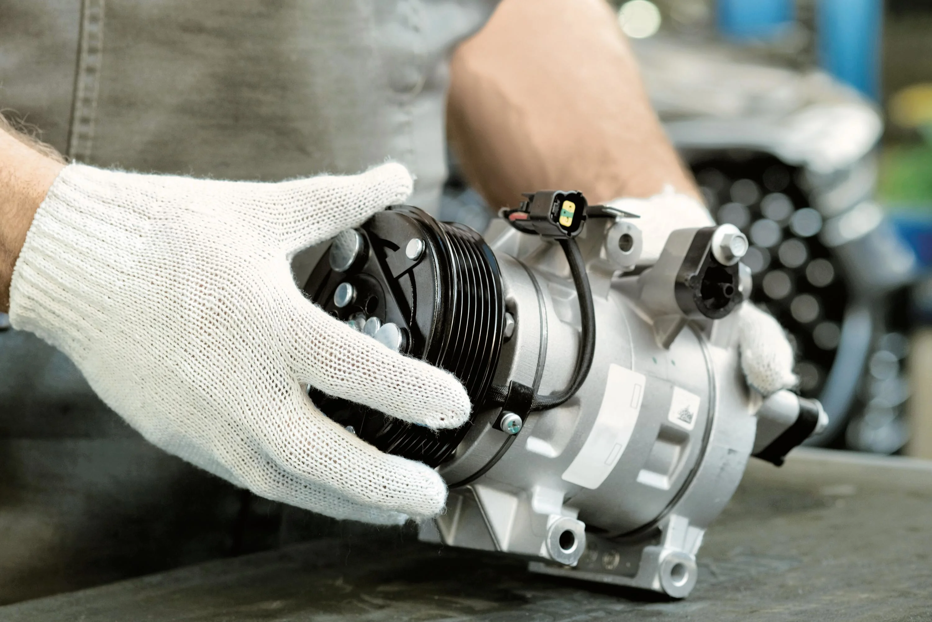 A technician inspects an HVAC compressor.
