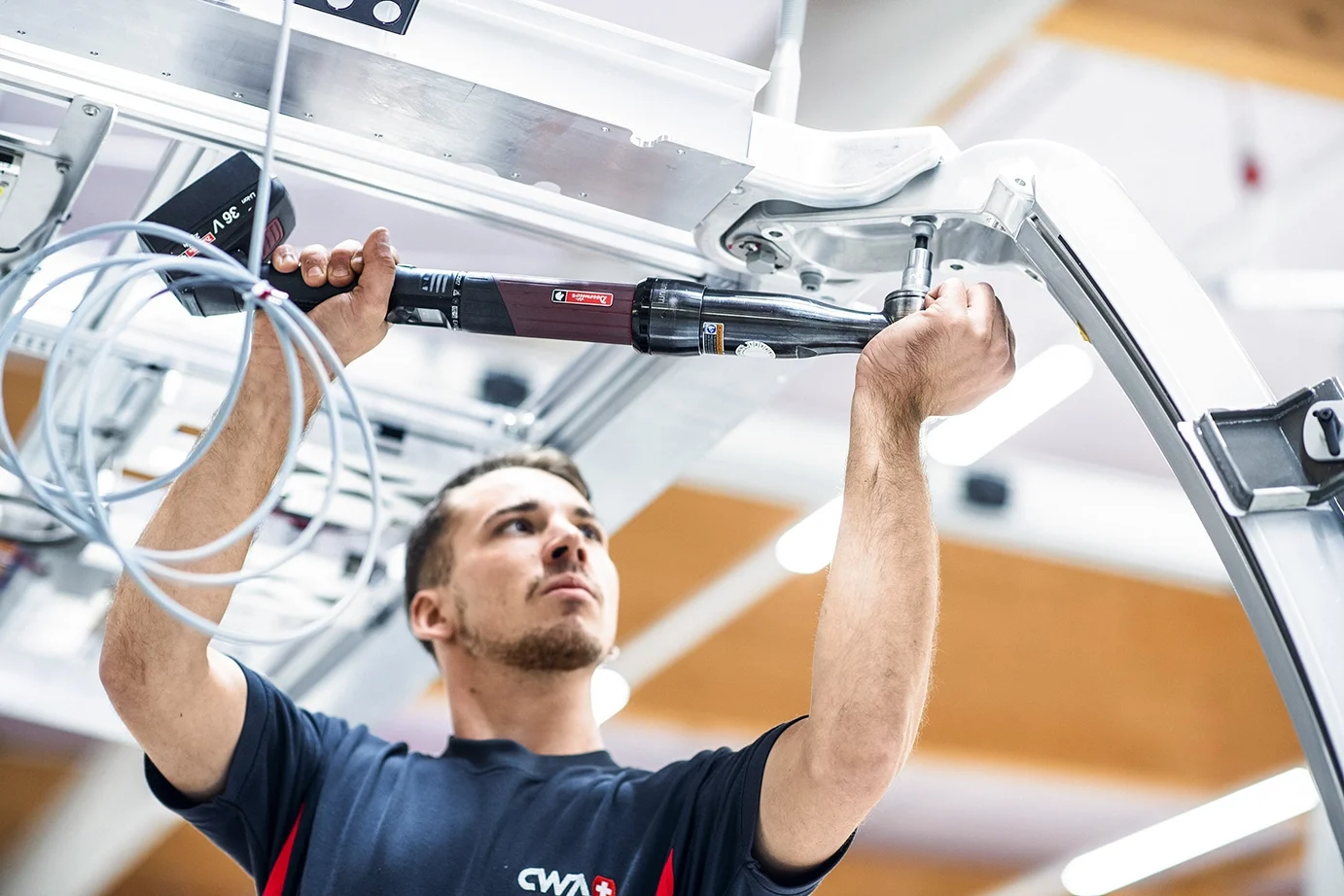 A man using a smart tool to fasten a screw into aluminium.